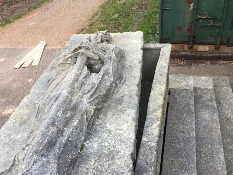 Recumbent skeletal figure sculpted into the tomb lid