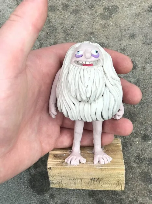 Small white-bearded plasticine character held in a hand