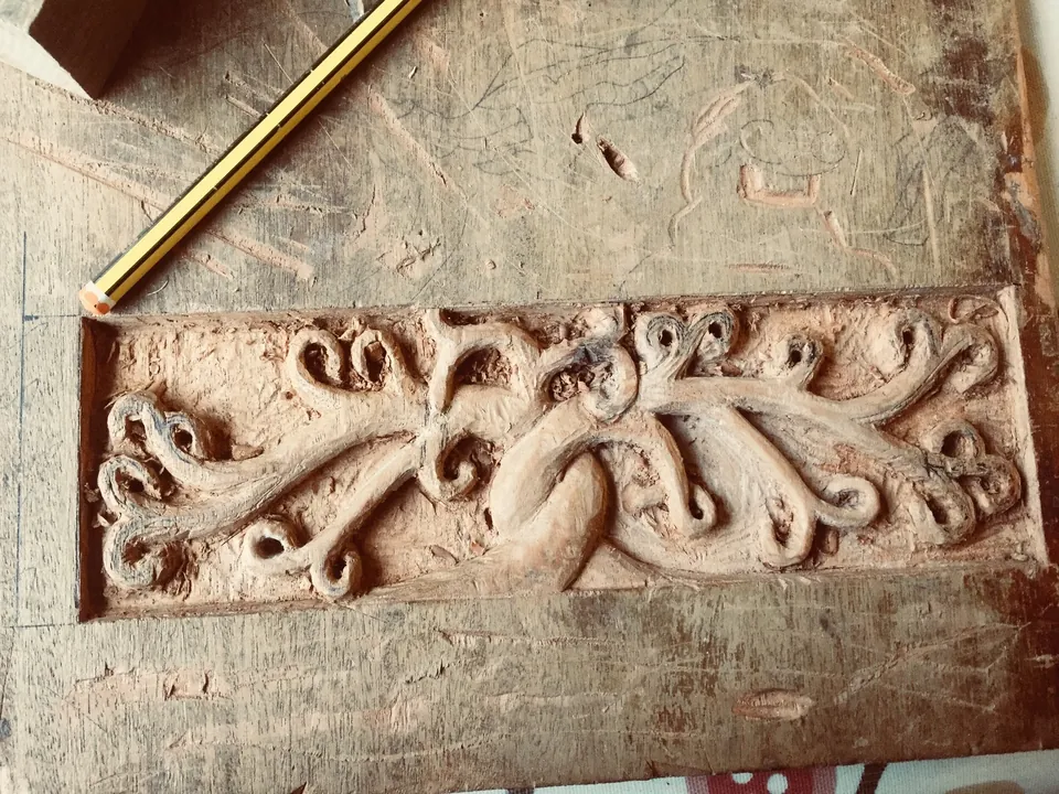 Decorative wood carving mounted beside a staircase