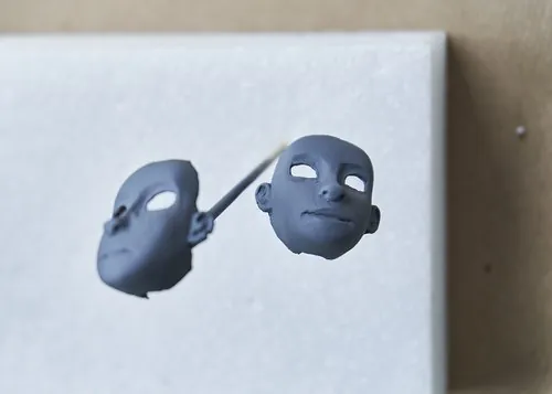 Two puppet face casts with openings for the eyes