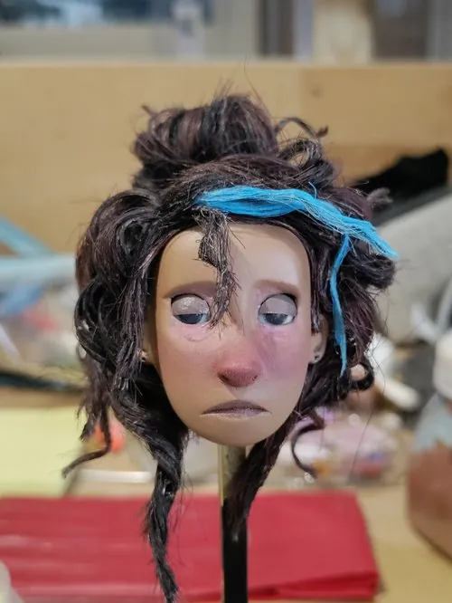 Close view of the finished puppet head with hair and expressive eyes