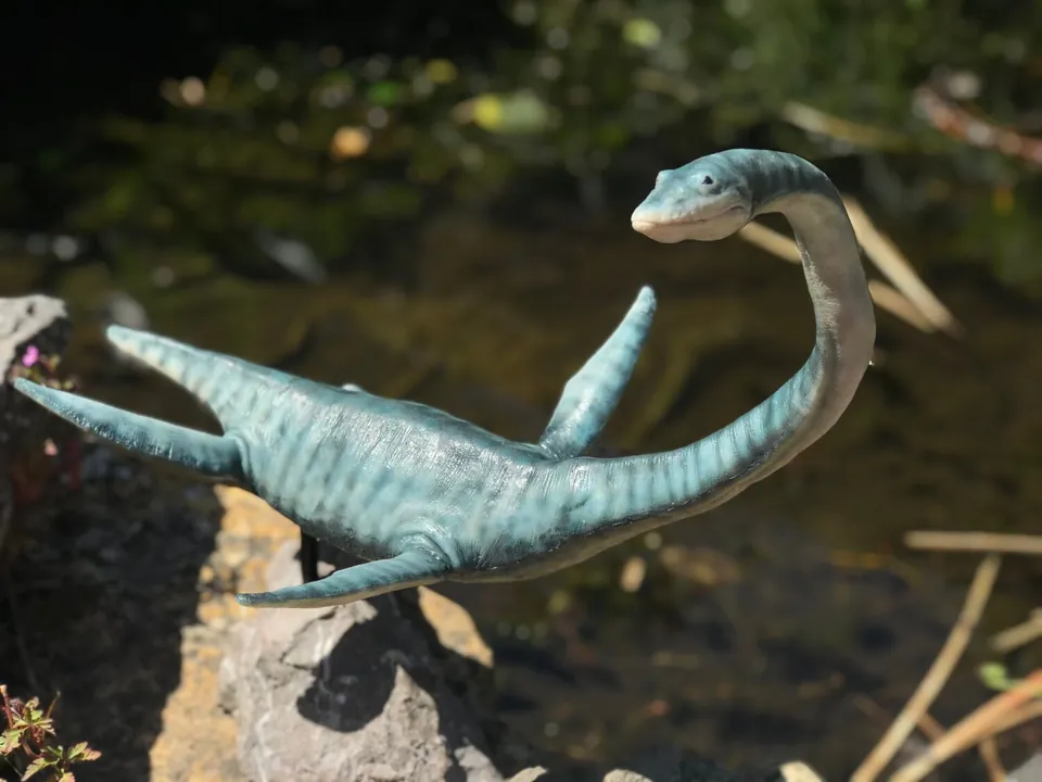 Close view of the puppet with its jaw open beside a stream