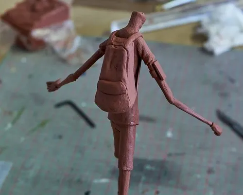 Clay character sculpture showing clothing and limbs