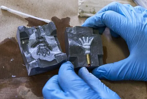 Opening a mould containing a small hand impression