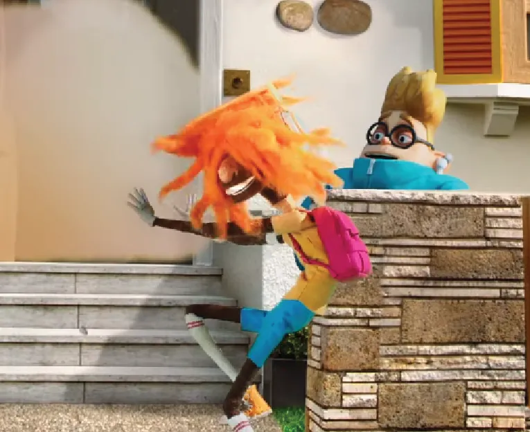 Orange-haired puppet and another character on a miniature set