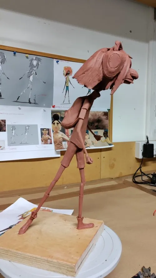 Unfinished character sculpture supported on a stand
