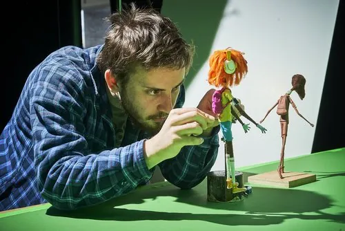 Matthew adjusting a puppet on a miniature set