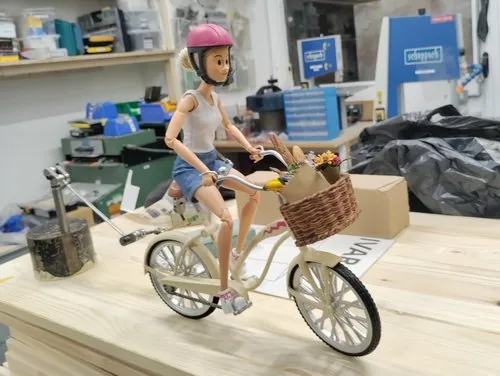 Puppet cyclist posed on a miniature bicycle