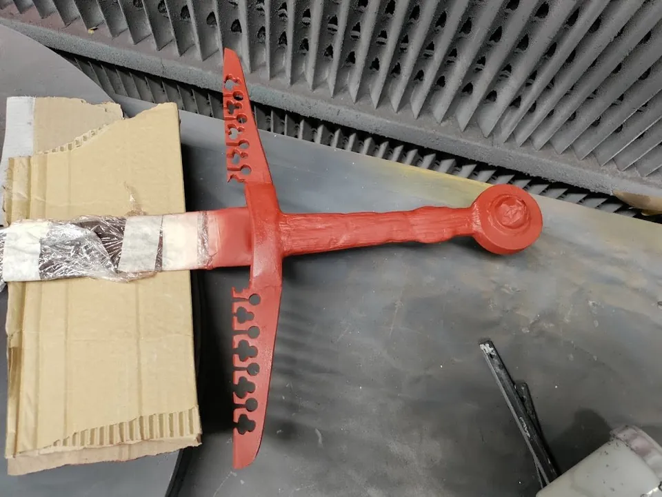 Red sword component during fabrication