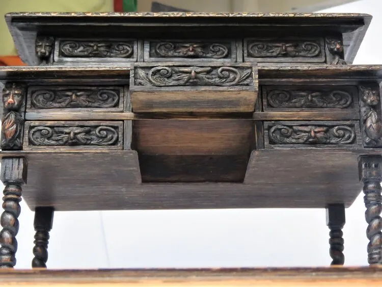 Rear view of the desk showing small drawers and carved detailing