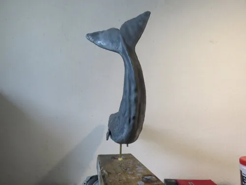 Whale puppet posed vertically on its display stand